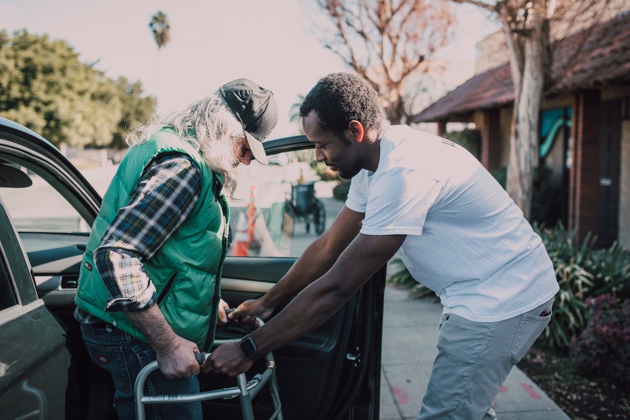 Man Assisting Person with Walker | Veteran Car Donations